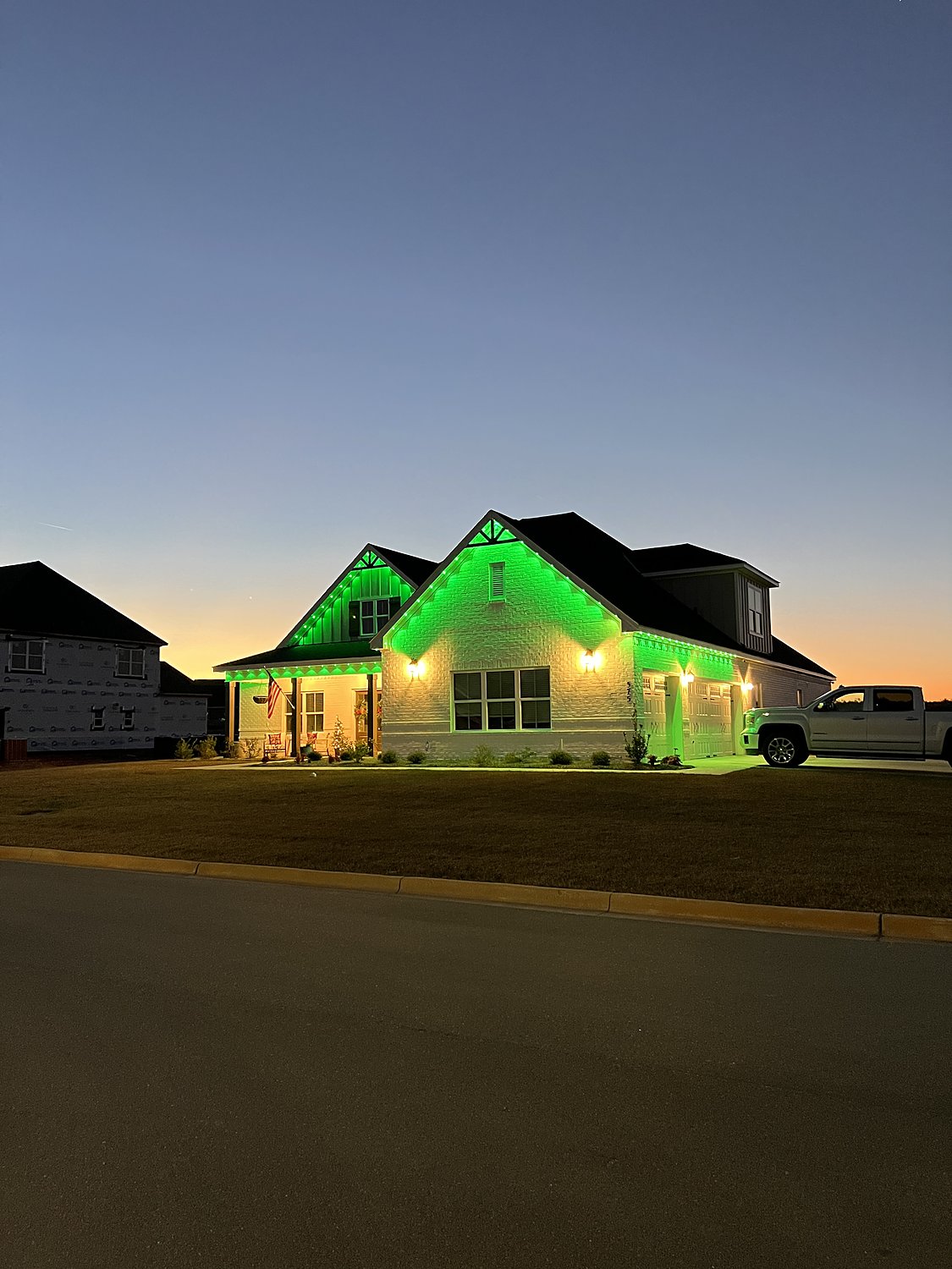Brick home with green color-changing permanent lighting
