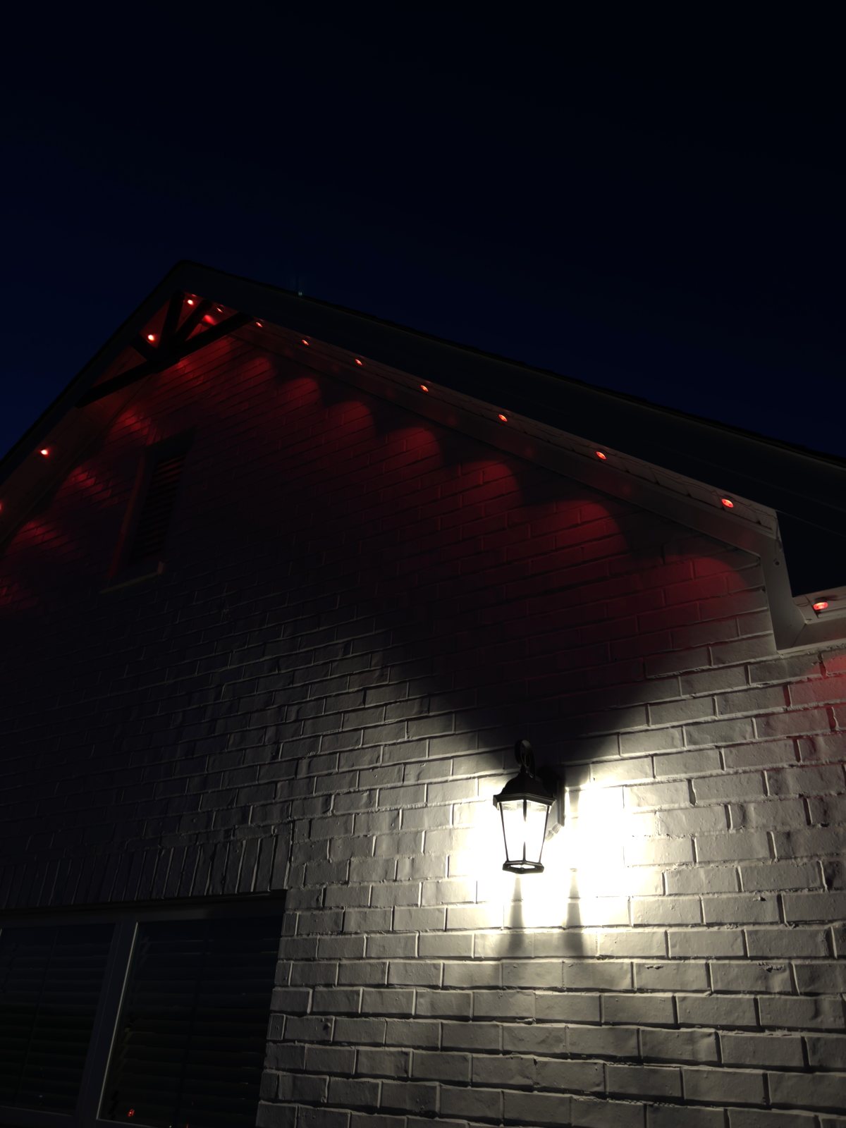 Close view of red permanent lighting tucked under the eave
